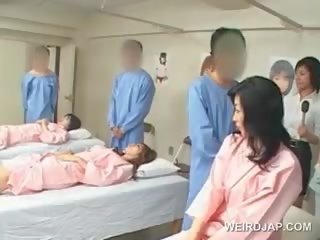 Azijietiškas brunetė jaunas moteris pučia plaukuotas narys į as ligoninė